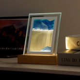 Moving Sand Art LED Lamp in Blue on a bedside table